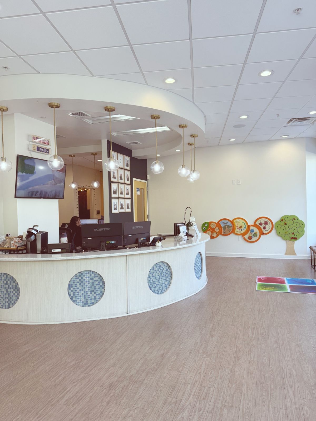 The curved front desk and check-in area, with play panels on the wall
