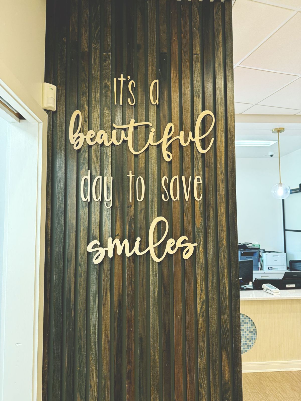 A wooden wall sign that reads: It's a beautiful day to save smiles