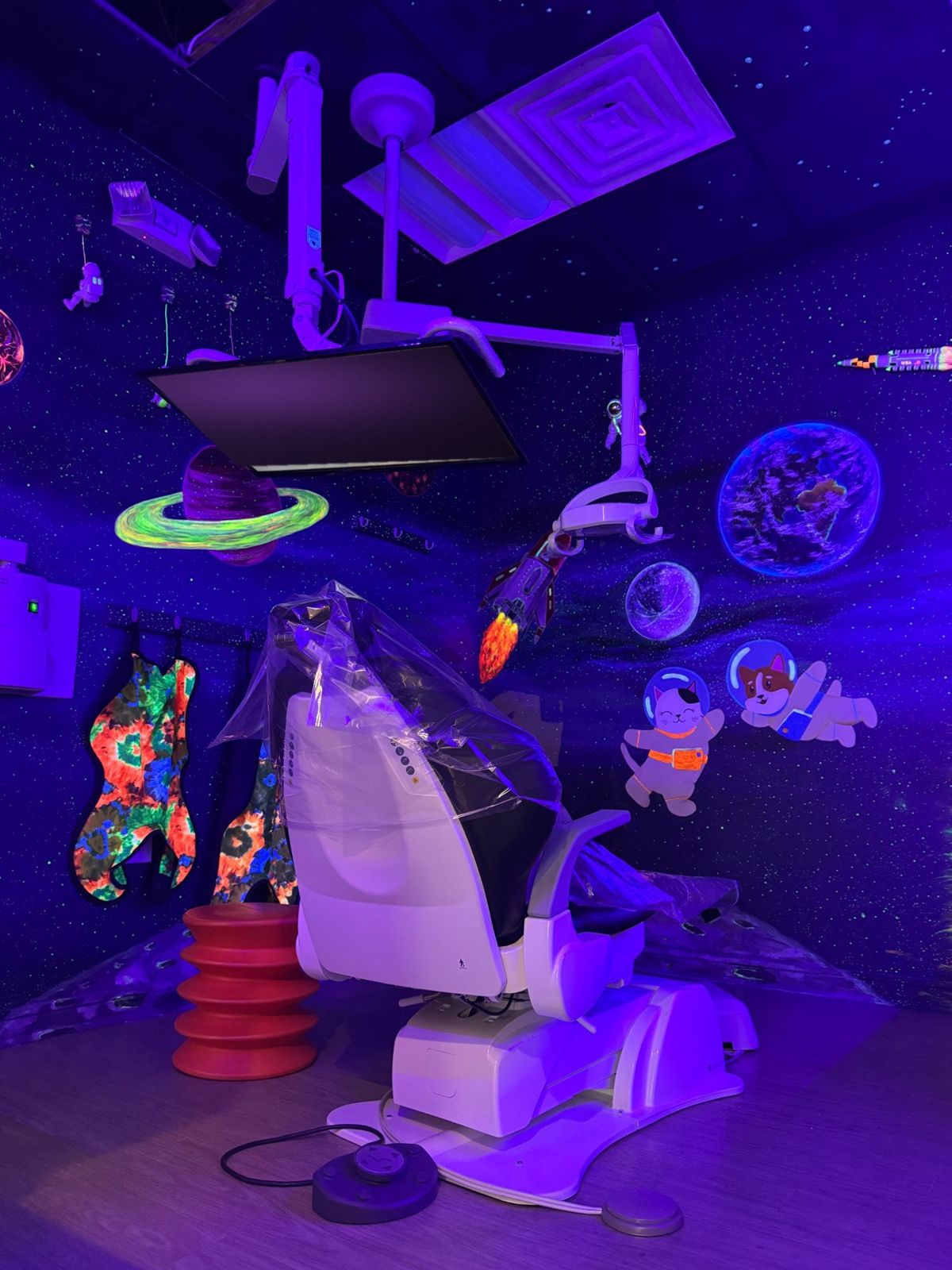 A treatment room painted like outer space that glows under black light